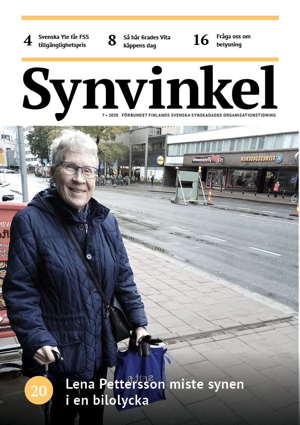 Leende Lena står med rollator på trottoaren och tittar i kameran.