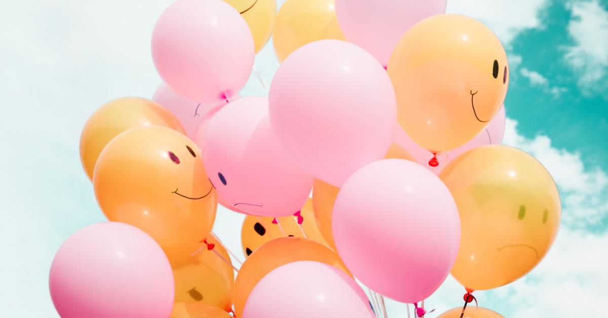 Ljusröda och orangea ballonger med smiley-ansikten