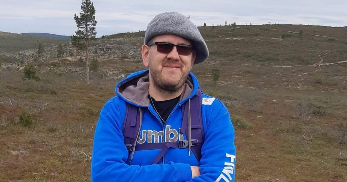 Axel i solglasögon och blå munjacka i ett fjällandskap.