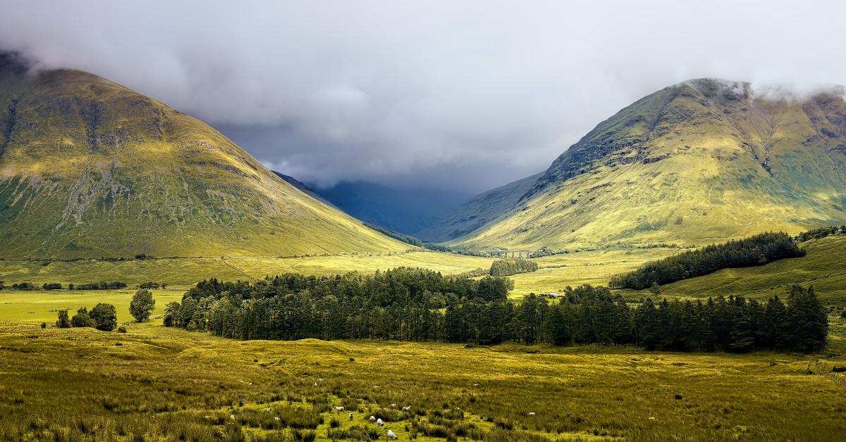 En grön dalvy i dimma, Glencoe i Skottland.