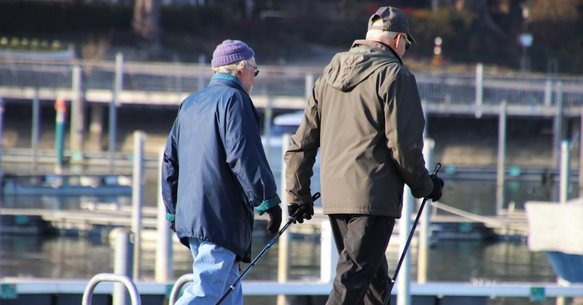 Två äldre personer är ute och går med stavar