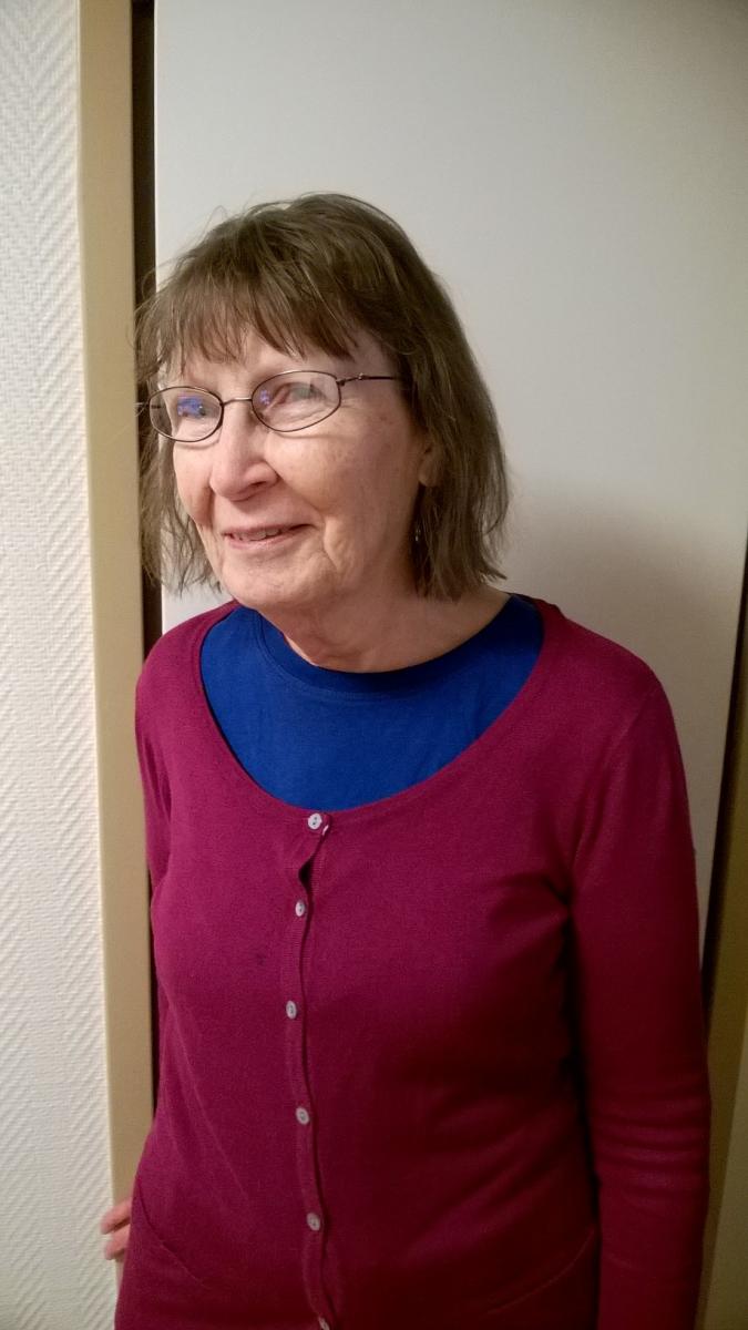 Barbro Puharinen i ljusröd kofta.