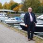 En bild på Bo vid en höstig hamn med motorbåtar i bakgrunden